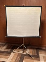 Front view of Knox Coronet collapsible projector screen on tripod stand showing screen surface and stand details.