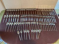 Full overhead view of large lot of flatware laid out on a table showing all cutlery types