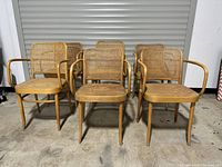 Six bentwood caned chairs arranged in two rows facing camera