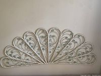Photo showing the full wicker peacock wall fan with intricate curved wicker pattern forming fan shape.