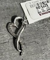 Close-up photo of the sterling silver heart-shaped pendant with diamonds and original tag from Kohl's.