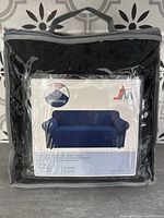 Front view of black stretch chair cover in clear zippered bag showing manufacturer's branding and product image.