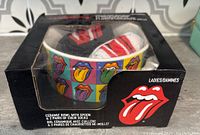 Box showing ceramic bowl with colorful tongue logo squares and two pairs of socks inside, along with the tongue logo sticker on the box front.