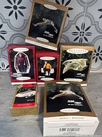 Photo showing six boxed Star Trek Keepsake Ornaments including ships and characters from various Star Trek series.