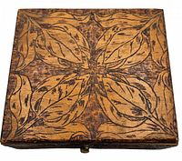 Top view of antique wooden box showing pyrography leaf design.