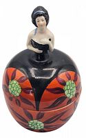 Front view of the ceramic powder jar with floral design and figurine lid.