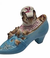 Front view of the Beswick ceramic figurine depicting a mouse woman sitting inside a blue shoe with mouse children surrounding her.