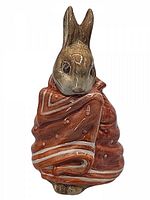 Front view of a brown and tan ceramic Peter Rabbit figurine wrapped in a red and white blanket, showing detailed face and ears.