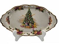 Full view of the oval serving platter on a display stand showing Christmas tree and gift design with Old Country Roses floral border.