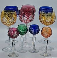 Full set of 10 Bohemian glasses including six wine glasses in blue, amber, ruby red and four colored liqueur glasses in ruby red, green, blue and amber hues.