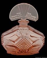 Frontal view of pink pressed glass perfume bottle with geometric diamond and fan motifs and fan-shaped stopper attached