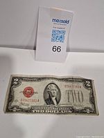 Front of 1928 $2 Silver Certificate showing Thomas Jefferson portrait, red Treasury seal, and serial numbers.