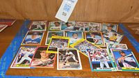 Photo showcasing a display of various baseball cards spread on a wooden surface, showing player front images and card designs.