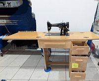 Singer foldable wooden sewing machine table with top open showing sewing machine mounted and drawers open with accessories inside.
