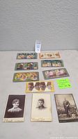 Seven vintage stereoscope cards and three portrait photos laid out on a table, showing front view of items and some details visible for identification.