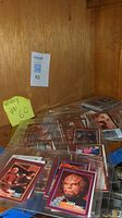 Photo showing multiple Star Trek trading cards in protective sleeves stacked in a corner.