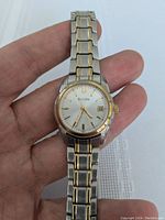 Front close-up of the Bulova women's watch showing the dial, gold-tone bezel, and two-tone stainless steel and gold bracelet.