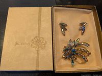 Box with Coro branding containing the jewelry set with brooch and earrings