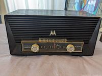 Front view of black Motorola MK-66X vintage radio with horizontal grill, Motorola emblem, and tuning display.