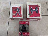 Three Star Wars Hallmark Keepsake Ornaments in original boxes: Jango Fett 2002, TIE Fighter 2003 with sound, Darth Vader figure ornament