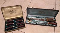 Two vintage carving sets with faux horn textured handles in original cases; one is a 6-piece steak cutter set by Debonair England, the other a 3-piece carving set by Glo-Hill Connoisseurs Choice with faux stag handles.