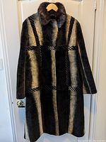 Full view of the women's winter coat showing the patchwork fur and suede texture design