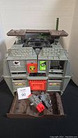 Front view of 1992 GI Joe Headquarters playset with visible stickers, foldable roof sections opened and missile launcher accessory placed in front.