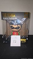 Front view of Dorbz XL Robin vinyl figure in black and gold Batman-themed box showing figure through clear plastic window