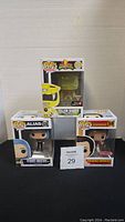 Three boxed Funko Pop figures: Yellow Ranger from Power Rangers, Alias Sydney Bristow, and Richard Simmons, displayed against a white backdrop