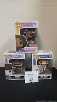 Three Funko Pop boxed figures including Whitney Houston, Westworld Teddy, and Mega Man Dr. Wily with visible boxes