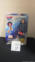 Photo of Mego Happy Days Chachi Arcola figure in original packaging, showing figure, red guitar accessory, and Happy Days branding.