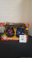 Boxed set of two remote control speed bumper cars in red and blue inside unopened packaging.