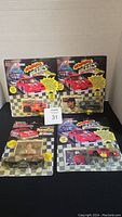 Four Racing Champions NASCAR Roaring Racers die-cast cars in original packaging displayed on black cloth with numbered tag for lot 31. Two cards in the back and two cards in front.