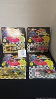 Four Racing Champions NASCAR diecast cars still sealed in original blister pack cards, showing front view of packaging and cars inside.