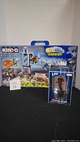Kre-O Cityville Invasion building set with Super Hero Iron Man LED figure displayed in front of cardboard backdrop.