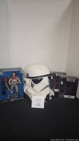 Star Wars helmet, diecast figure, and two pin sets displayed together showing the entire lot contents