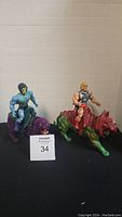 Photo showing vintage Skeletor figure mounted on purple Panthor and He-Man figure mounted on green and orange BattleCat.