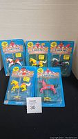 All five toy carousel horses in their original unopened packaging, displaying front and center of each horse along with packaging details.