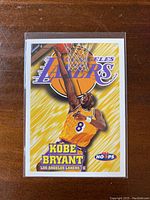Front view of the 1997-98 NBA Hoops Kobe Bryant trading card showing Kobe dunking with Lakers logo.