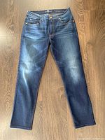 Front view of the blue denim skinny jeans laid flat showing overall condition and color.