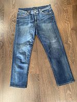 Front view of the Fidelity ladies denim jeans laid flat on wooden floor showing slight fading and vintage style.