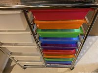 Close view of the colorful pullout drawers alongside the larger clear drawers within the metal frame.
