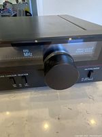 Close-up of tuning knob and servo locked tuning system indicator on the Sansui TU-S33 stereo tuner.