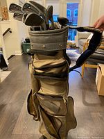Golf bag holding clubs vertically on floor indoors