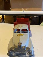 Front view of vintage metal toy dump truck showing the Lincoln logo on the hood and gray-painted cab.