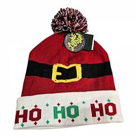Front view of red knit hat with black belt and yellow buckle design, white cuff with HO HO HO text in red and green, and pom-pom on top.