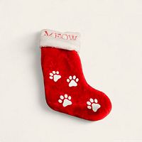 Front side of the red plush Christmas stocking showing four white paw prints and the 'Meow' embroidered white cuff