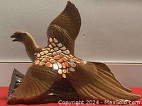 Side view of the brown hand painted porcelain bird lamp with wing details and cut-out sections