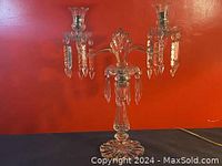 Full view of the French double crystal candle stick holder with lustres against a red background, showing overall size and shape.