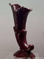 Front view of the Quebec Art Craft ceramic vase, showing its glossy burgundy finish and sculptural floral petal design